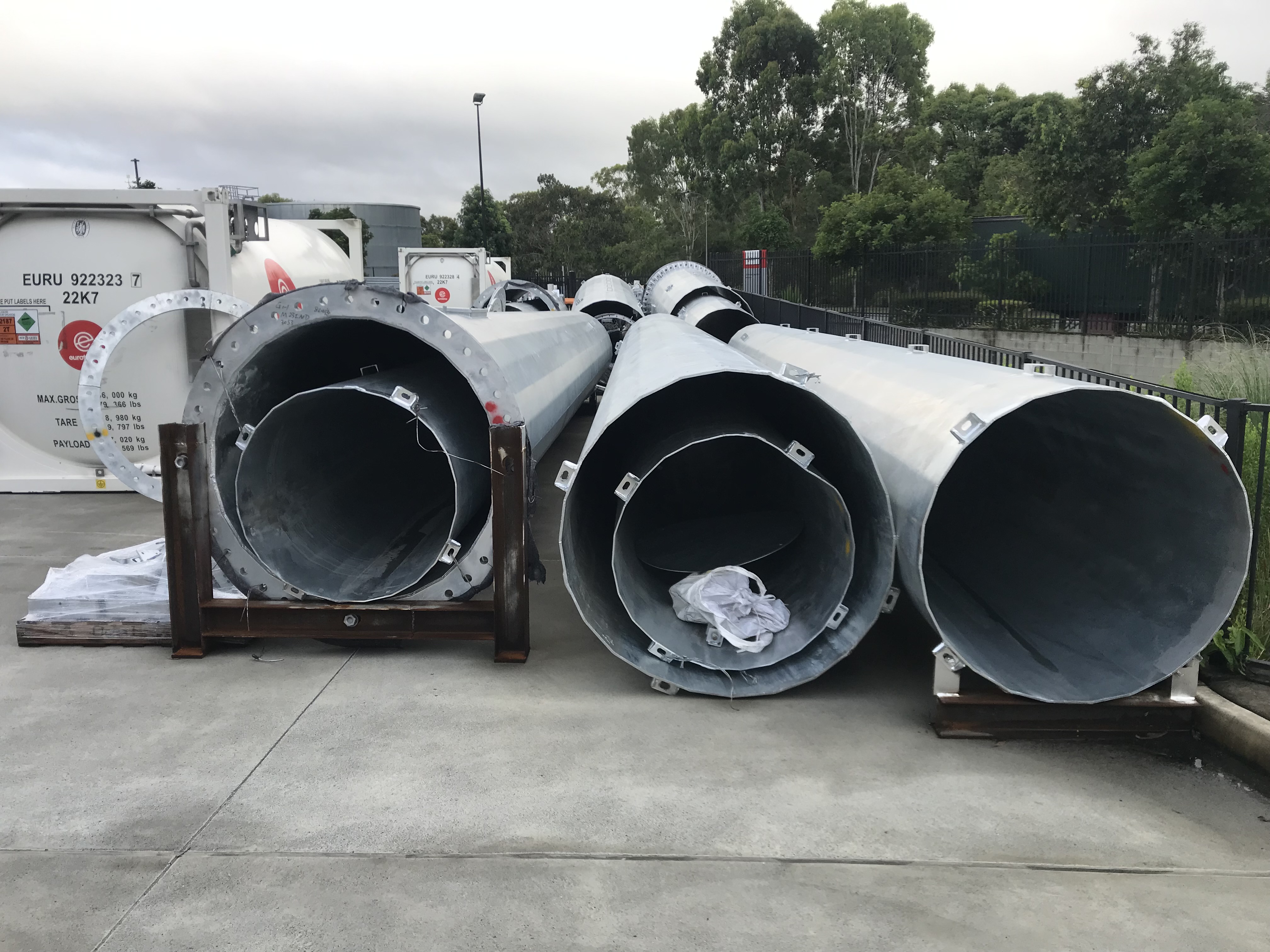 Large cylindrical freight components stored in a yard