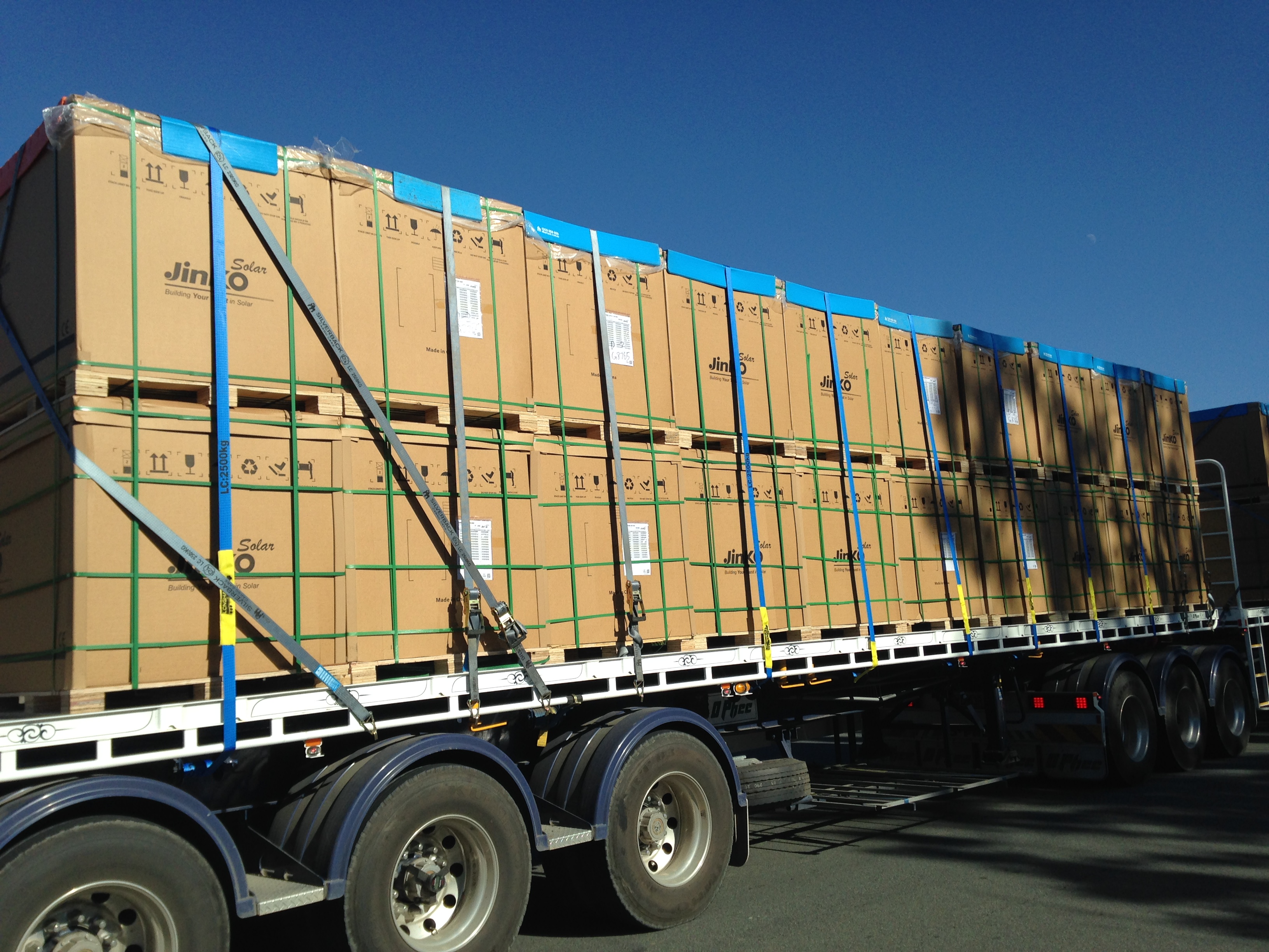 Boxed solar equipment secured on a flatbed trailer